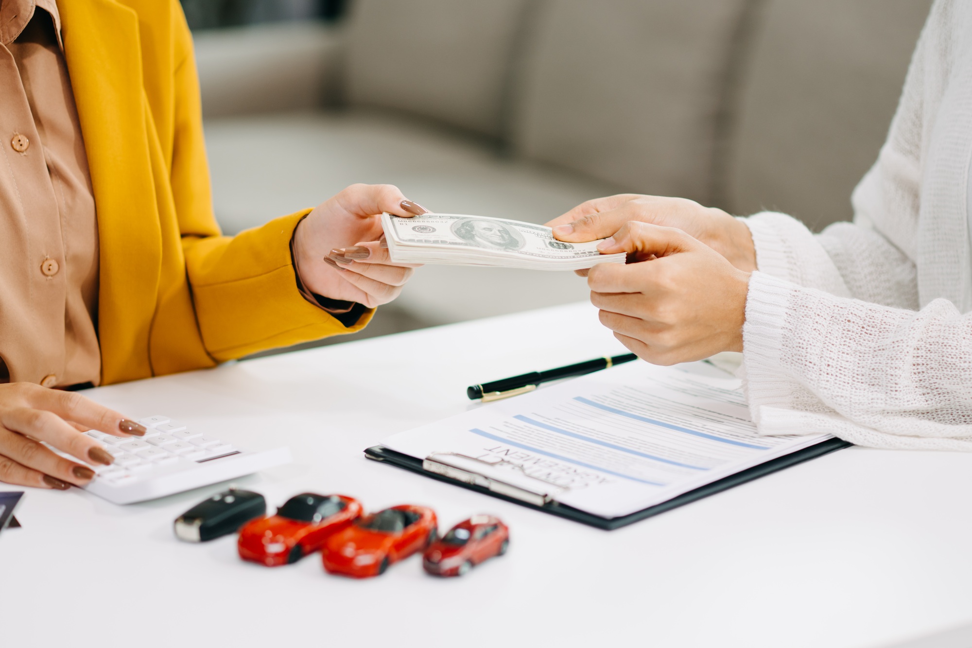 Asian people car salesman or sales manager offers to sell a car and explains of signing a car